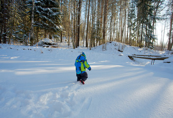 little boy playing in sunny winter day