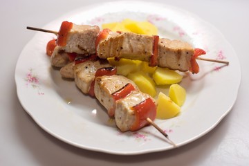 Grilled tuna fish skewer with red pepper and boiled potatoes. Simple and health diner very easy to cook, suitable for reduction weight diet. Served on the vintage white plate isolated.