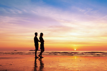 Fototapeta premium Couple sharing a romantic moment together on the beach, sunset