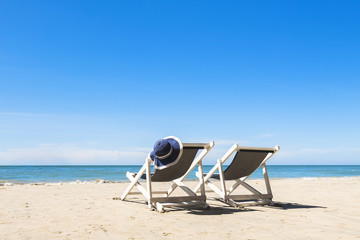 Two deck chairs and hat, relaxing on the beach, sunny