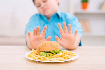 Chubby kid refuses to eat unhealthy food. 