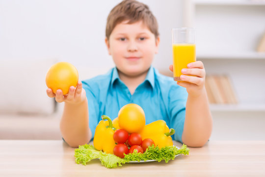 Chubby kid demonstrating healthy products. 