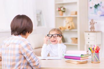 Laughing little girl trying on her moms glasses.