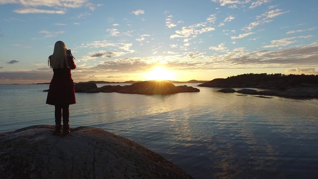 A girl taking pictures of the Sunset