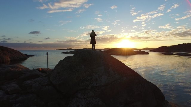 A girl taking pictures of the Sunset