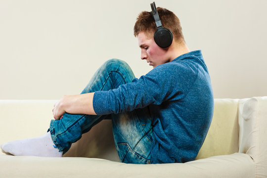 Young man with headphones on couch