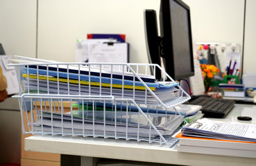 White  basket of documents on the desk