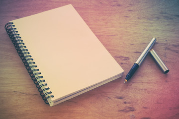 paper notebook and pen on a table with filter effect retro vinta
