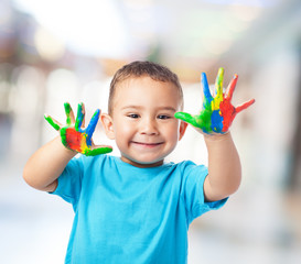 portrait of cute kid having fun with hands paint