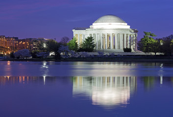 Colorful sunrise over Tidal Basin during cherry blossom festival in Washington DC, USA. Thomas Jefferson Memorial at dawn in cherry trees blooming season.