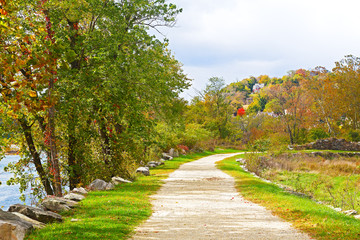 Appalachian trail along Shenandoah River near Harpers Ferry historic town in West Virginia, USA. Autumn colors of deciduous trees and scenic view on Harpers Ferry town buildings.