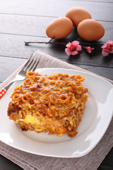 Baked pasta with peas, eggplant and egg