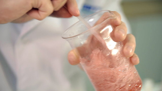 The laboratorian is checking the quality of soap base