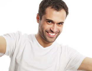 Obraz premium young man holding camera and making selfie 