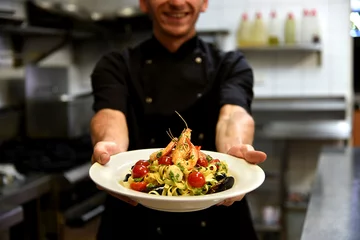 Rolgordijnen Happy chef holding delicious pasta © tagliaferriphoto