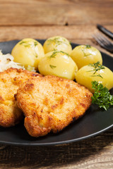 Fried pork chop in breadcrumbs, served with boiled potatoes and