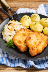 Fried pork chop in breadcrumbs, served with boiled potatoes and