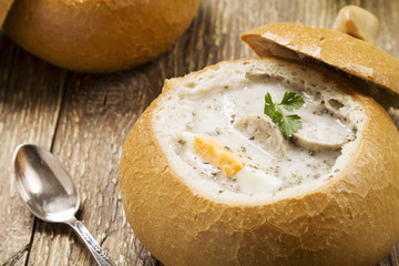Traditional polish white borscht with eggs and sausage in bread
