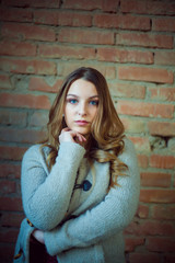 beautiful girl portrait white sweater brick background