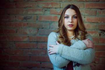 beautiful girl portrait white sweater brick background