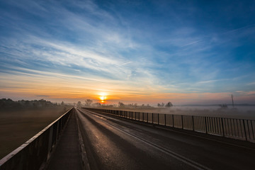 Naklejka premium Wschód słońca widziany z mostu na rzece Warta