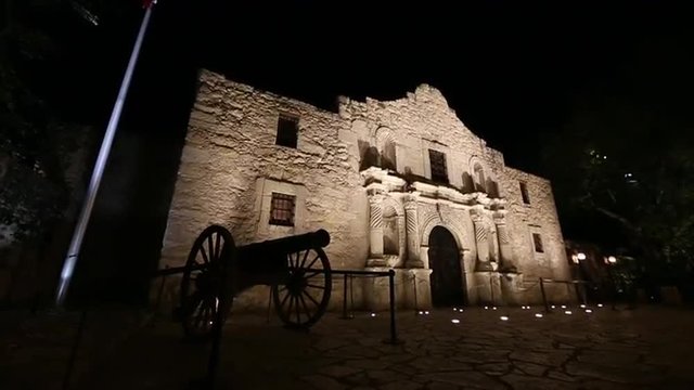 Slow downward panning view of the Alamo at night.
