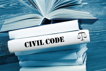 Book with Civil Code word on table in a courtroom or enforcement office. Toned image