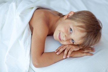 Fototapeta na wymiar happy little boy in morning bed 
