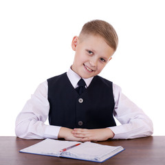 Caucasian school boy at his desk on white background with copy s