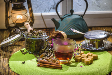 Kettle with green tea and a glass cup on a wooden table