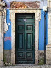 Naklejka premium Antique abandoned building facade with green wood door