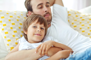 Happy father with son lying on the sofa