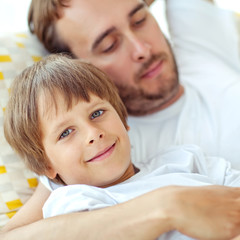 Happy father with son lying on the sofa