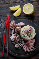 Top view of octopuses with brown rice on a rustic chopping board
