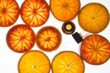 orange essential oil in amber bottle with blood orange slices  - 100271525