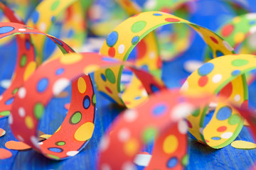 Luftschlangen an Karneval, Silvester oder Geburtstag auf blauem Hintergrund