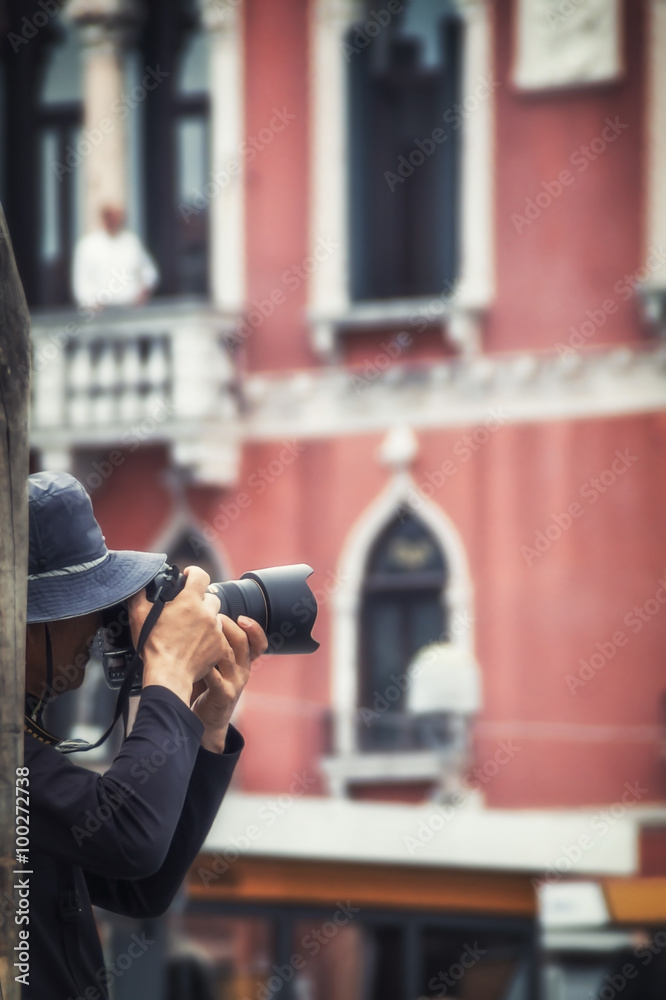 Wall mural photographer records a snapshot on the background of Venetian ho