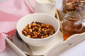 Homemade granola with nuts and dried cranberries with milk and honey. Horizontal permission. Selective focus