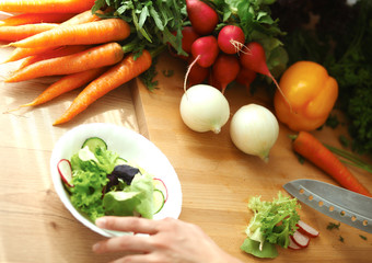 Young woman cutting vegetables in the kitchen
