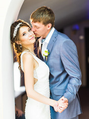 Wedding couple holding hands and embracing.