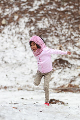 Happy little girl jumping on snow