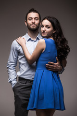 young happy smiling attractive couple, isolated on grey background