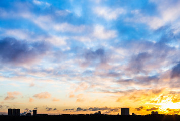 sunset sky with clouds over urban houses in winter