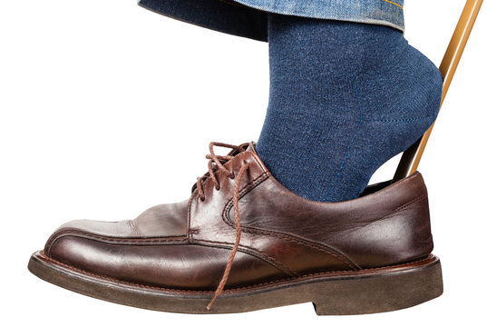 Man Puts On Brown Shoes Using Shoe Horn Isolated