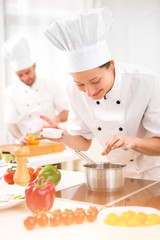 Young attractive professional chef cooking in his kitchen