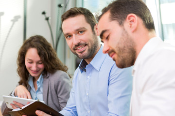 Fototapeta premium Young attractive businessman working at the office with associat