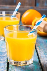freshly squeezed orange juice in a glass with straws