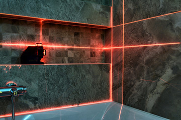 Laser measurement during bathroom renovation, red laser mapping
