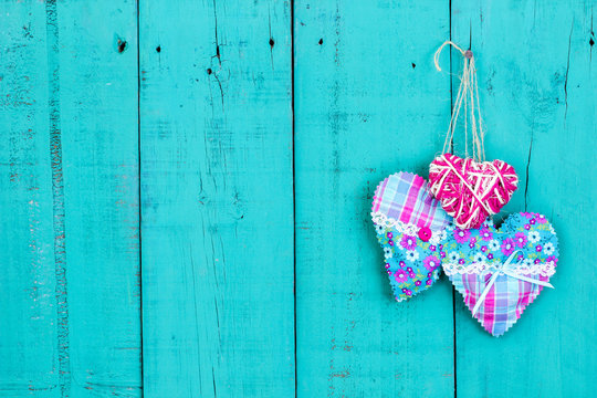 Colorful hearts hanging on rustic teal blue door