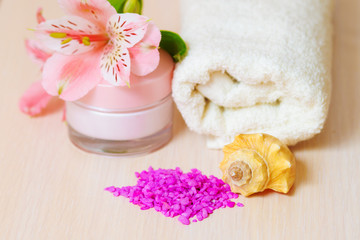 Obraz na płótnie Canvas Cosmetic moisturizing cream towels and pink flowers